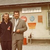 zwei Männer vor einem Gebäude mit Schild Buffett